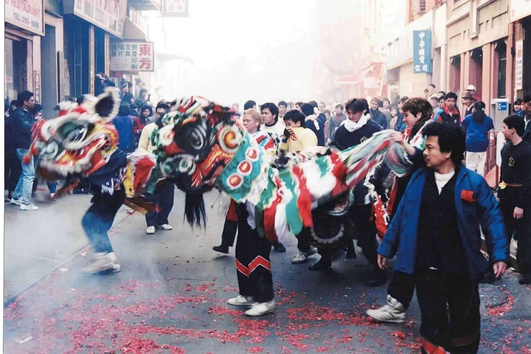 Ying Yee Kwoon Lion Dance procession moving through a crowded Chinatown street