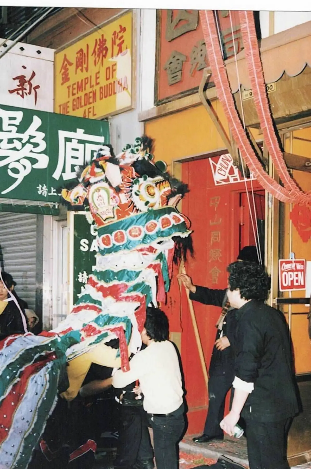 A green, white, and red lion rising at the entrance of a Chinatown association