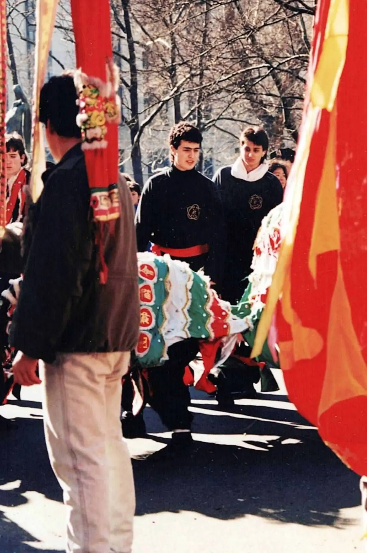Young Ying Yee Kwoon students walking beside a green, red, and white lion