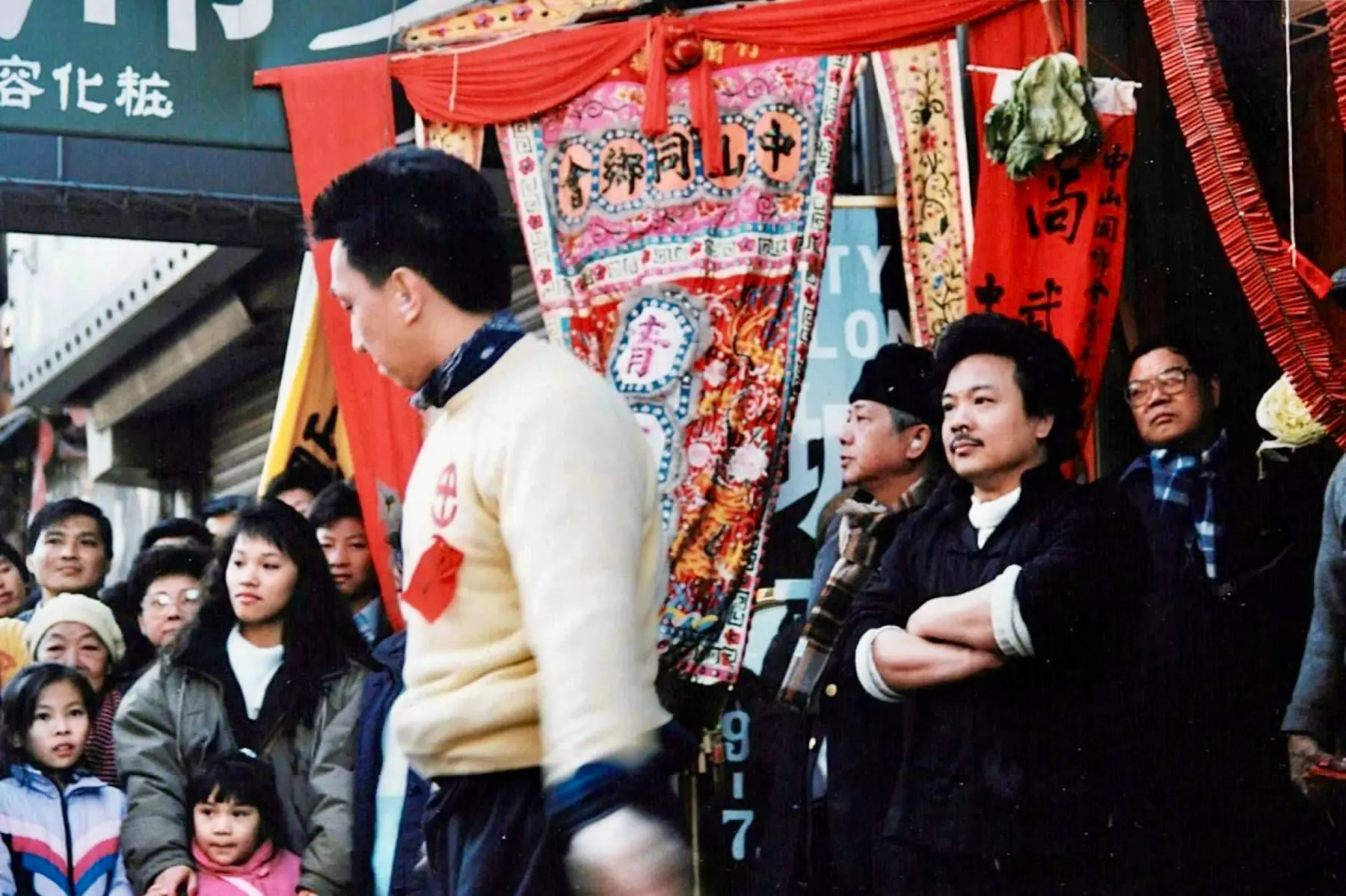 Sifu Tony Lau standing with folded arms as he watches a Chinatown demonstration