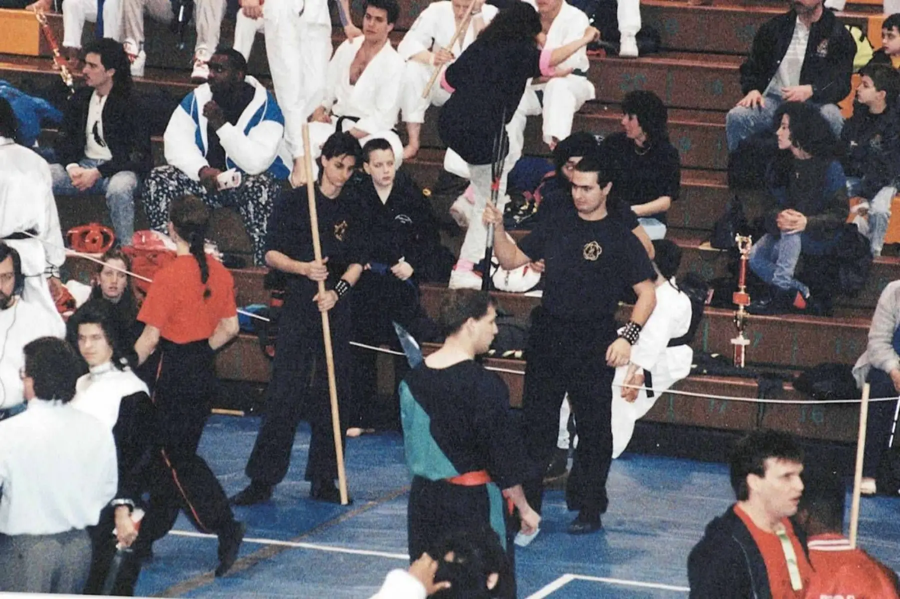 Ying Yee Kwoon students gathered with staffs and other competitors at a martial arts tournament